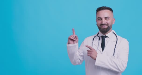 Recomendación profesional. Médico sonriente señalando a un lado el espacio de copia y asintiendo con la cabeza — Vídeos de Stock
