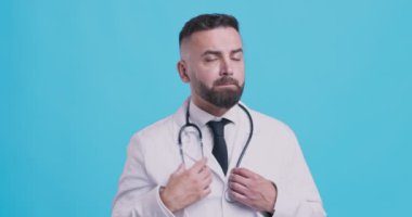 Tedirgin doktor tedavi planını düşünüyor, ellerini ovuşturuyor, mavi arka plan