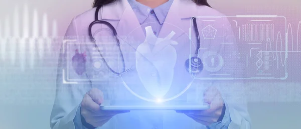 Chirurgen untersuchen technologisches digitales Hologramm. Tablet stellt leuchtendes Herz des Patienten dar — Stockfoto