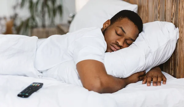 Rápido dormido negro hombre durmiendo abrazando almohada descansando en casa — Foto de Stock
