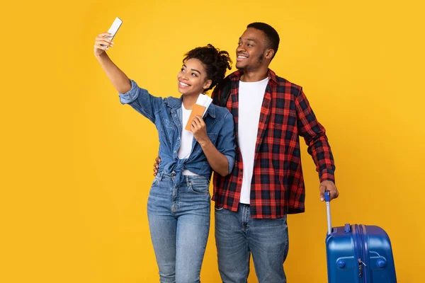 Pareja africana haciendo selfie en Smartphone celebración de entradas, fondo amarillo — Foto de Stock