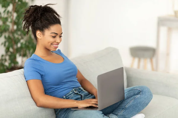 Allegro africano freelancer ragazza utilizzando computer portatile di lavoro a casa — Foto Stock