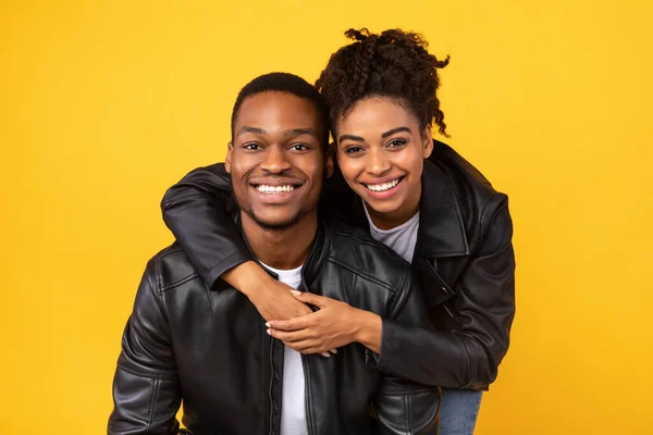 Bella coppia afro-americana che si abbraccia in posa in studio, sfondo giallo — Foto Stock