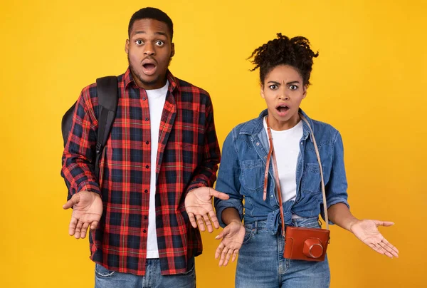 Choqué couple afro-américain voyageurs ayant des problèmes de vacances, fond jaune — Photo