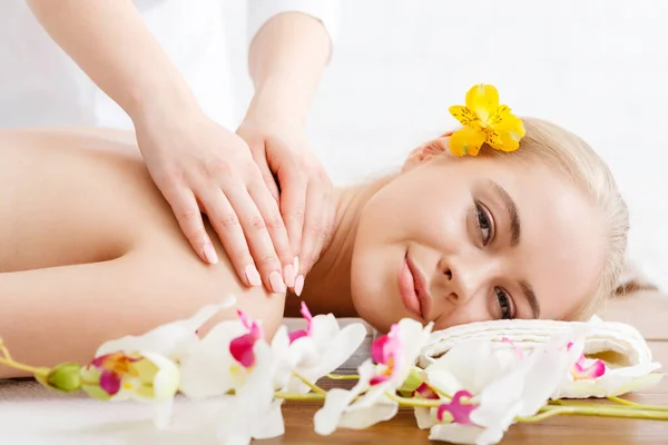 Relajarse en el spa. Mujer sonriente en la mesa de masaje —  Fotos de Stock
