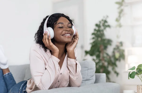 Kochanek muzyki. Relaxed African Lady korzystających z ulubionych piosenek w słuchawkach w domu — Zdjęcie stockowe
