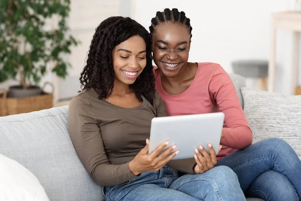 Lächelnde schwarze Frauen mit digitalem Tablet zu Hause — Stockfoto