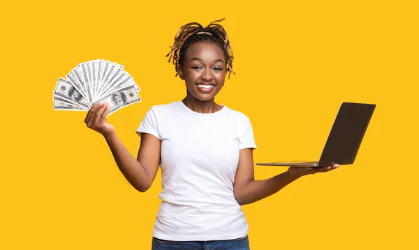 喜びの黒女性とともに現金とラップトップ上の黄色 — ストック写真