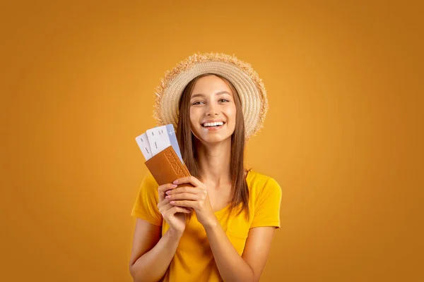 Vidám nő nyári kalapban, útlevéllel és jegyekkel. — Stock Fotó