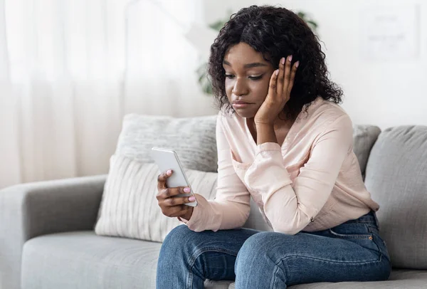 Verveling. Droevige zwarte dame besteedt tijd met Smartphone thuis — Stockfoto