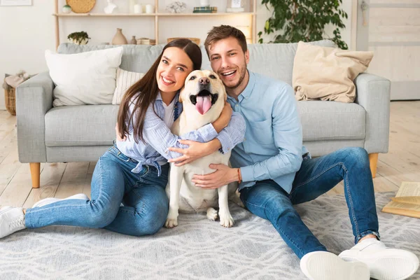 Fiatal boldog házastársak kutyával otthon pózolnak — Stock Fotó