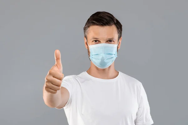 Homem com máscara protetora médica mostrando o polegar para cima — Fotografia de Stock