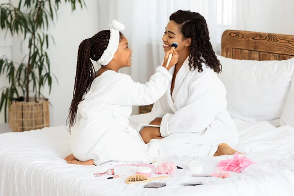 Allegro nero madre e figlia in accappatoi giocare bellezza salone a casa — Foto Stock