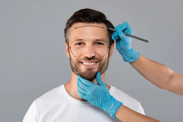 Homme souriant obtenir des marques de crayon sur la peau avant la chirurgie — Photo