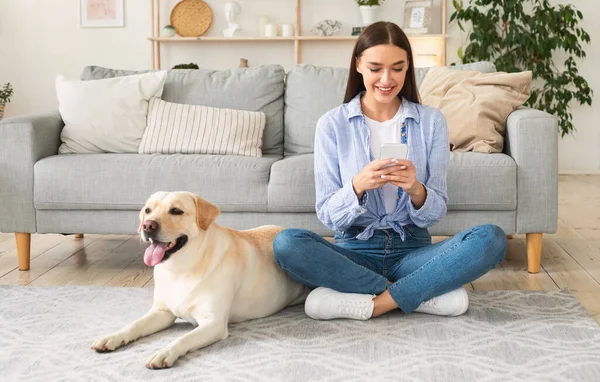 Retrato de la joven con su perro usando el teléfono móvil — Foto de Stock