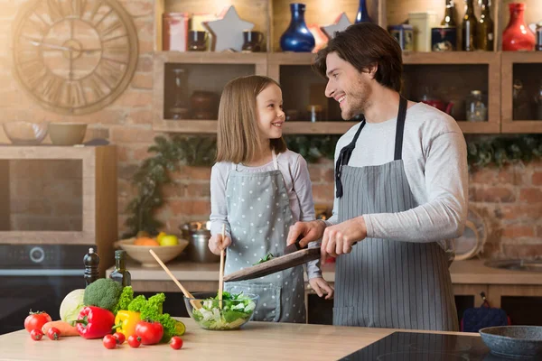 Mutlu küçük kız ve babası mutfakta taze sebze salatası yapıyor. — Stok fotoğraf