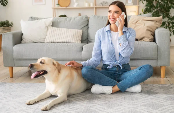 Porträtt av ung dam med sin hund med hjälp av mobil — Stockfoto