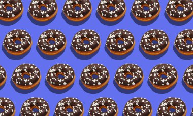 Sağlıksız tatlılar ve müşteriler için lezzetli fast food. Çikolatalı çörekler ve mor arka planda beyaz kırıntılar.