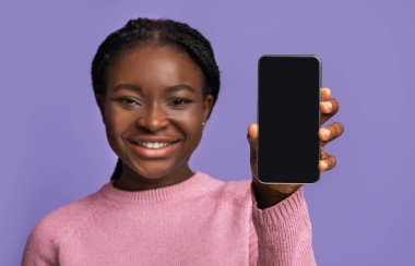 Harika bir uygulama. Siyah ekranlı, modern akıllı telefonu elinde tutan Afrikalı kadın.