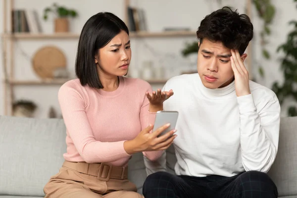 Asiática esposa mostrando infiel marido su teléfono sospechoso asunto en interiores —  Fotos de Stock