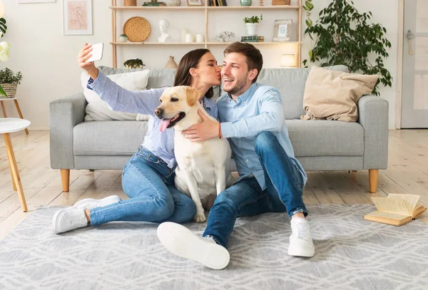 Jeune couple prenant selfie avec leur chien dans le salon — Photo