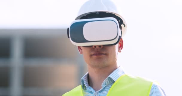 Ingénieur en lunettes VR visualisant le plan de construction sur le site de construction, en utilisant l'interface du futur, le suivi des prises de vue — Video