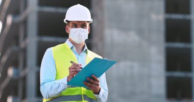 İnşaat alanında planı olan koruyucu maske ve kask kontrol binası sahibi profesyonel bir ustabaşı.