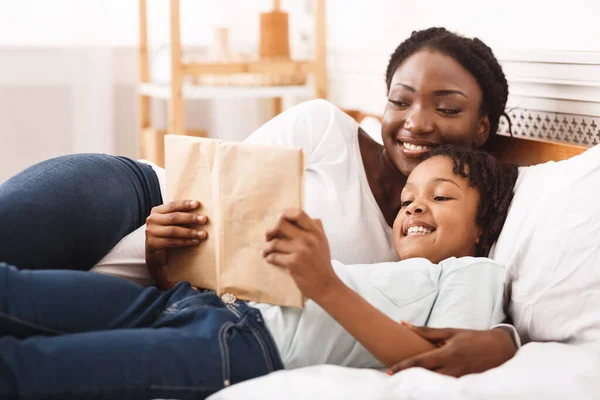 Libro de lectura familiar afro feliz en el dormitorio — Foto de Stock