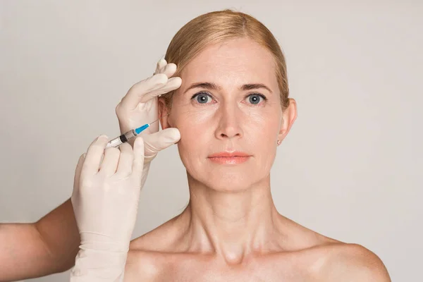 Chirurgia plastyczna. Kobieta w średnim wieku otrzymująca wstrzyknięcie botoksu — Zdjęcie stockowe
