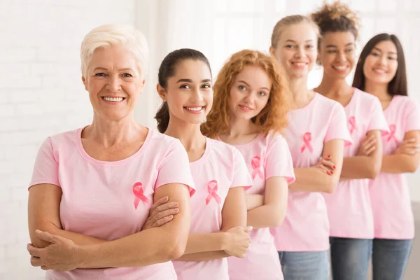 Mulheres em camisetas com fitas de conscientização em pé sobre fundo branco — Fotografia de Stock