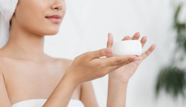 Банка со сливками в руках молодой азиатки