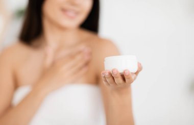 Havluya sarılmış, omzunu nemlendiren tanınmayan Asyalı kadın.