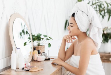 Makyaj yapan güzel Asyalı kadının yan görünüşü