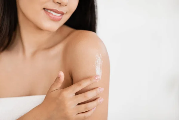 Joven asiática dama envuelta en toalla hidratando su piel — Foto de Stock