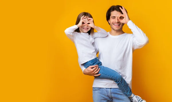 Gioioso papà e figlia avendo buon tempo su sfondo giallo — Foto Stock