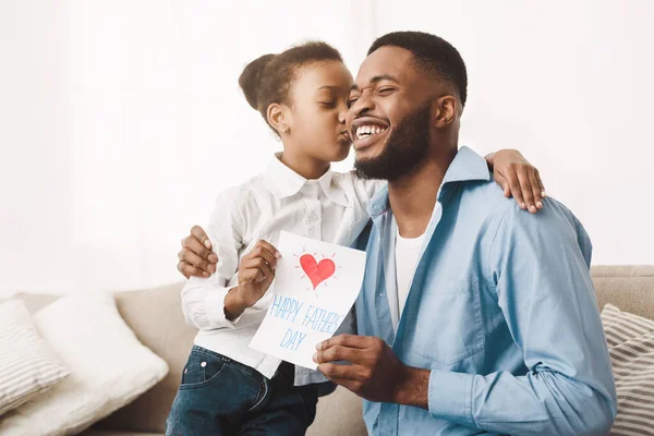 Linda afro hija besando papá y dando tarjeta de felicitación —  Fotos de Stock