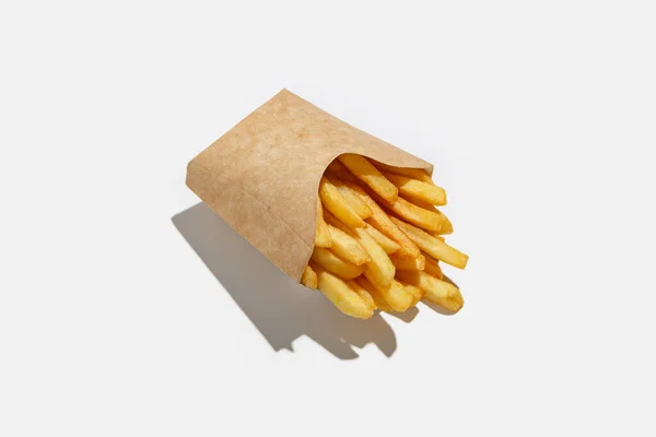 Frites et plats à emporter dans le menu pendant la pandémie. Pommes de terre frites dans un emballage écologique en papier avec ombre — Photo
