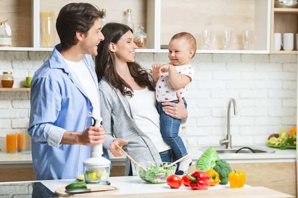 Üç kişilik mutlu bir aile mutfakta birlikte yemek pişiriyor. — Stok fotoğraf