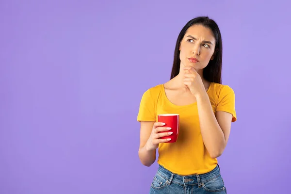 Pensive mulher segurando caneca de café no estúdio — Fotografia de Stock