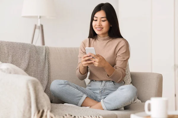 Chica alegre mensajes de texto en el teléfono inteligente, disfrutando de fin de semana —  Fotos de Stock