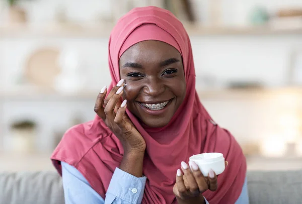 Hidrasi Kulit. Black Muslim Woman Menerapkan Cream Moisturizing On Face At Home — Stok Foto