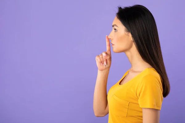 Perfil retrato de mulher colocando o dedo nos lábios — Fotografia de Stock