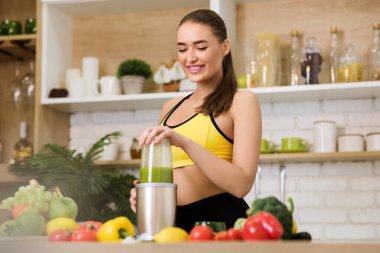 Sağlıklı yiyecekler. Sportif kadın blender ile sağlıklı smoothie hazırlıyor.