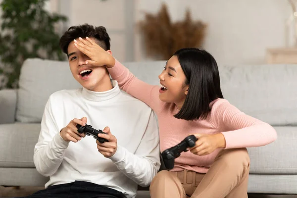 Gelukkig koreaans vriendje en vriendin spelen videospelletjes thuis — Stockfoto