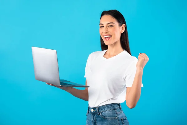 Ευτυχισμένο θηλυκό μοντέλο γιορτάζει νίκη κρατώντας φορητό υπολογιστή — Φωτογραφία Αρχείου