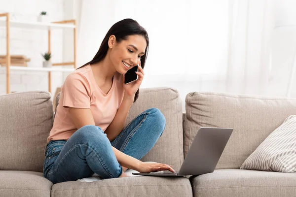 Mulher falando no celular sentado no sofá — Fotografia de Stock