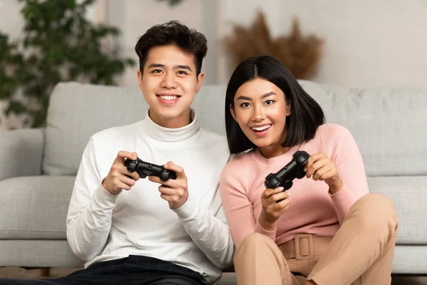 Glad asiatisk pojkvän och flickvän spelar TV-spel hemma — Stockfoto