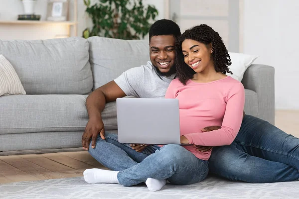 Amar grávida casal afro-americano usando laptop em casa — Fotografia de Stock