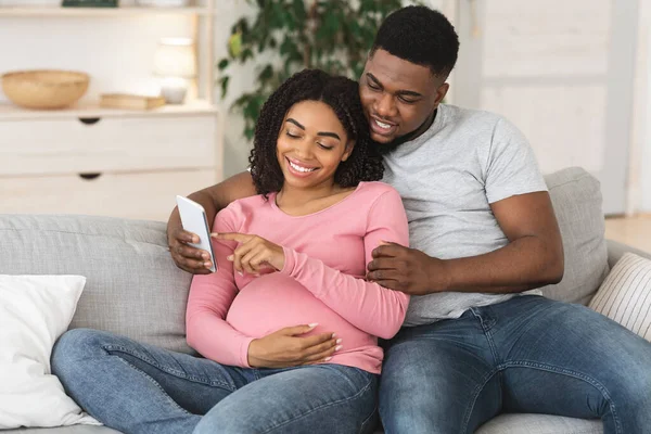 Casal preto grávida usando smartphone juntos em casa — Fotografia de Stock