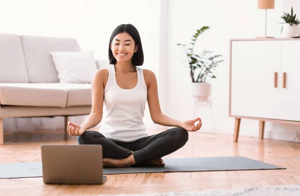 Millennial kvinna meditera med tränare online på laptop — Stockfoto